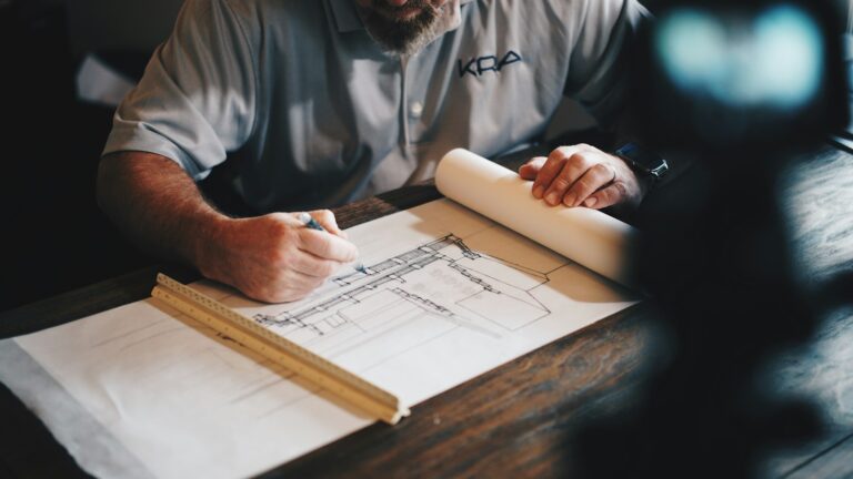Architect working on building plans and drawings at a desk
