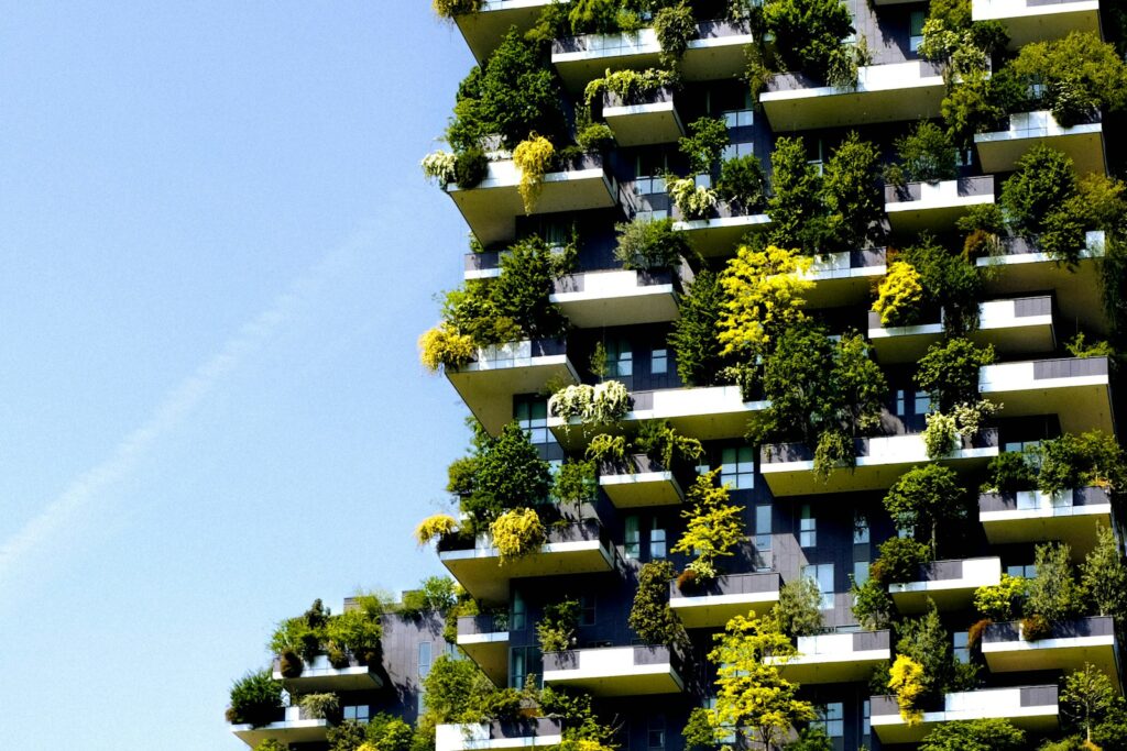 High-rise building with planted terraces and greenery growing on its facade